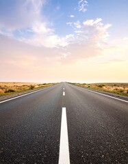 A long open road stretching into the distance under a beautiful sky at sunset.