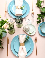 Elegant dining table set with blue plates, greenery, and glassware for a stylish meal or gathering.