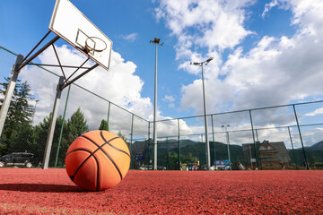 A classic orange basketball on an outdoor court.