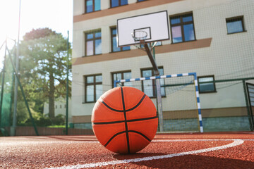 A classic orange basketball on an outdoor court.