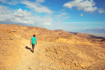 The young man is hiking in the mountain desert. Eilat mountains in the Negev desert, Israel