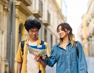 Portrait of a smiling couple loking at a map in the city, tourists visiting destination, summer trip exploring