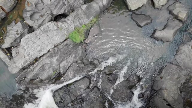 Drone Floating Shot Over Small River Flowing Through Rocks in Tropical Forest