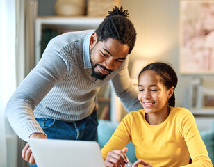 Father and daughter doing homework with laptop at home. Father and teenage girl happy using laptop....