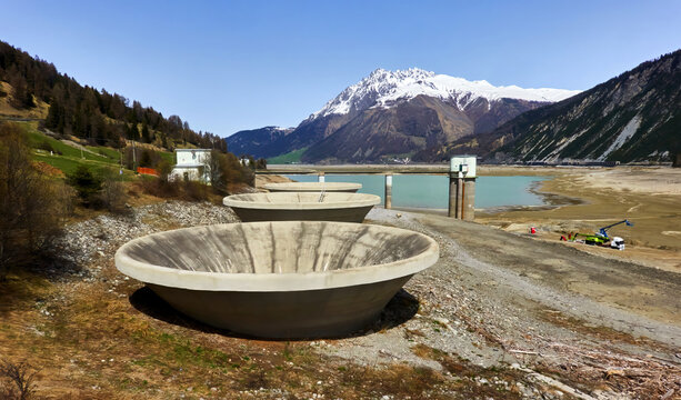 Dried spillway funnels in drained reschen dam, alps, italy