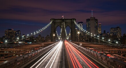 Fototapeta premium Long exposure captures the illuminated Brooklyn Bridge at twilight, with city lights.