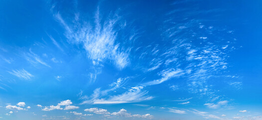 Fan-shaped cirrus clouds scattered by the wind across the daytime sky. A picture drawn by the wind....