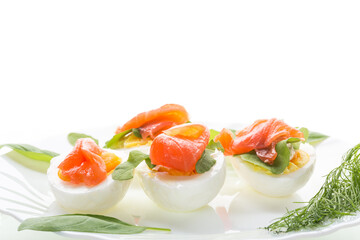 Portioned appetizer with egg halves and salmon on a white background