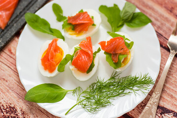 Portioned appetizer with egg halves and salmon on a plate