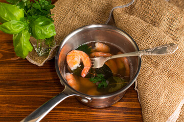 Seafood red shrimps in a pan, on a wooden table