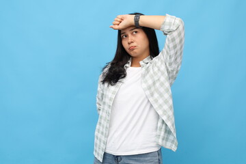 Tired and sad young Asian woman wearing casual clothes, hand on forehead suffering from headache,...