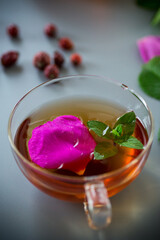 Homemade rosehip and mint tea in a transparent cup and teapot
