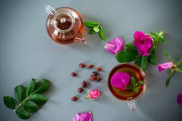 Homemade rosehip and mint tea in a transparent cup and teapot