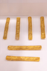 Top view close-up of golden objects, archaeological finds in a museum display. Archaeology concept.