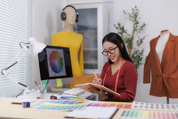 Fashion designer sketching new clothes collection in her office
