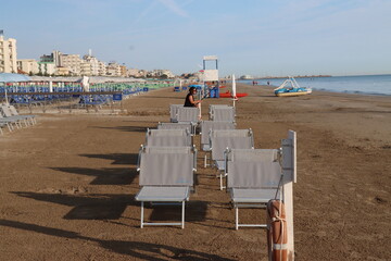 Beach worker preparing deckchairs on the beach in the morning