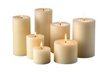 Group of lit pillar candles of varying heights isolated on transparent background