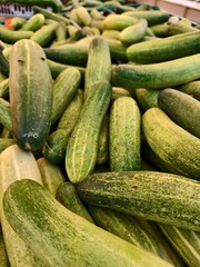 Crisp, cool cucumbers, a vibrant green, piled high in a market display.