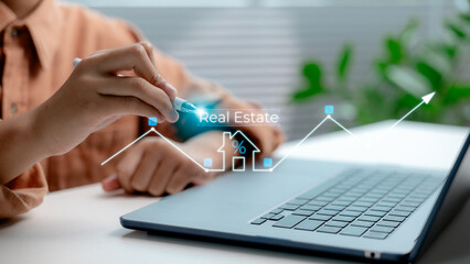 Hand analyzing real estate investment trends with digital interface on laptop, showing housing...