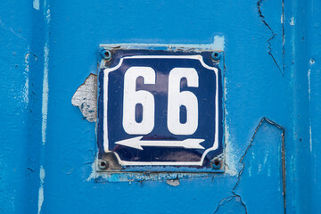 Weathered grunge square metal enameled plate of number of street address with number 66