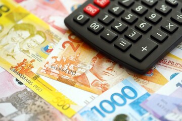 Philippines peso currency money bills and calculator. The concept of taxation and money count