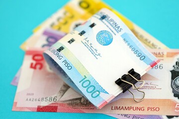 Philippines peso money bills in big amount on blue. Finance and banking concept