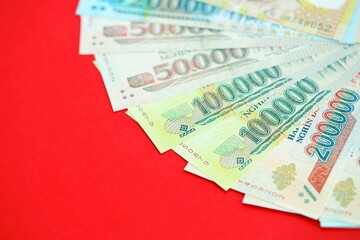Vietnamese dong money bills in big amount on red. Finance and banking concept