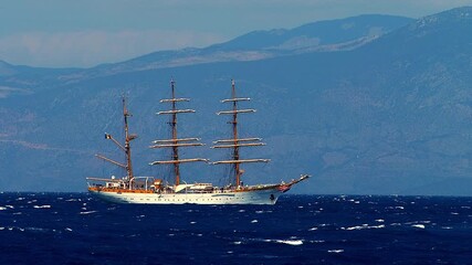 A beautiful white three masted sailing ship rides the blue sea, its graceful silhouette steady against the rhythmic motion of the waves. - Powered by Adobe