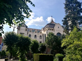 Fototapeta premium Palace of Culture in Targu Mures, Romania, features an intricately designed facade with decorative elements and ornate rooftop details. Its architecture blends Art Nouveau and Secession styles