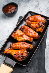 Juicy barbecue chicken wings, perfectly grilled and glazed, ideal for your next summer cookout or party. grey background. top view