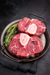 Freshly cross cut shank osso buco, ossobuco meat featuring succulent meat and bone marrow, waiting to elevate your cooking experience. black background. top view