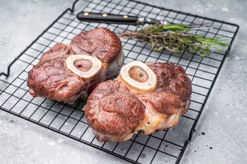 Tender veal osso buco, cross cut shank simmered in rich sauce, a timeless recipe that delights the senses and warms the heart. grey background. top view