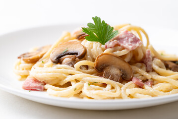 Spaghetti carbonara with ham, bacon and champignon mushroom on plate, Italian food