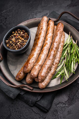 Juicy grilled sausage sizzling on the barbecue, perfect for summer cookouts and outdoor gatherings. black background. top view