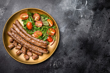 Close up of perfectly charred grilled sausage with salad, ideal for adding flavor to your favorite dishes or sandwiches. black background. top view