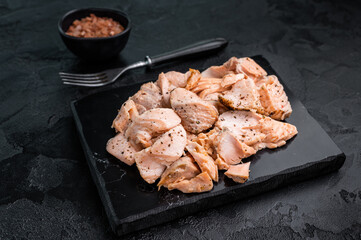 Shredded salmon, roasted fillets on a marble board. black background. Top view