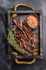 Beef fritter, Deep fried beef tender strips, sliced meat in a tray. black background. top view