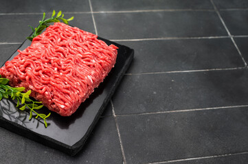 Raw beef and pork mince meat, mincemeat, on black background.