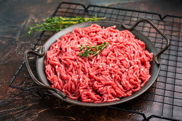 Fresh Raw pork and beef ground mince meat, mincemeat in a plate on brown background.