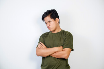 A Young Asian Man Crossing Arms and Displaying Displeased Expression Against White Background