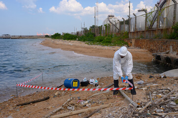 A male and female biologist are analyzing water test results and collecting samples for...