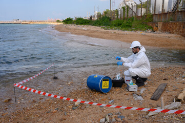 A male and female biologist are analyzing water test results and collecting samples for...