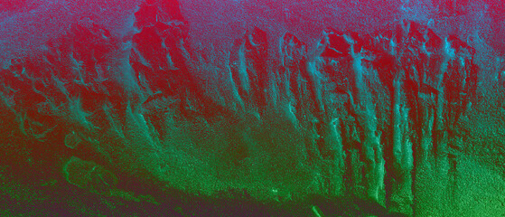 The image is an abstract representation of a vibrant, possibly natural, landscape, dominated by contrasting shades of red and green, suggestive of a dynamic and energetic scene.