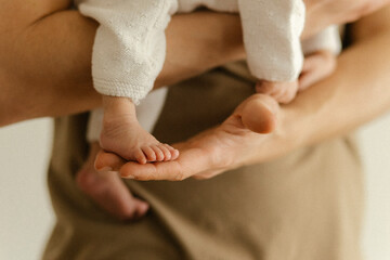 Parent tenderly holding baby's feet expressing care and love