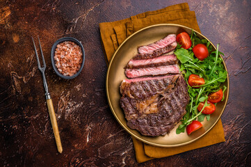 Dinner with Grilled Rib eye steak, fried dry aged beef meat. brown background. top view