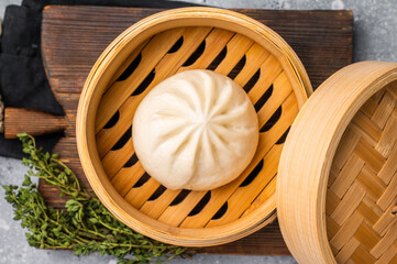 Chinese Bao or Baozi bun with meat in bamboo steamer. grey background. top view