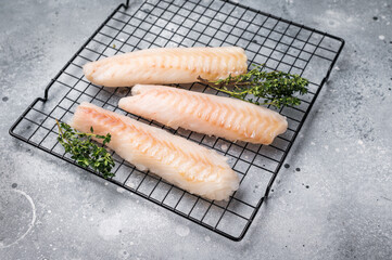 Fresh raw cod fish fillet, Boneless white fish meat. gray background. top view
