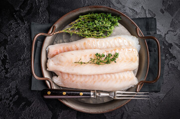 Raw Loin cod fish fillets ready for cooking whitefish in stell tray. black background. top view