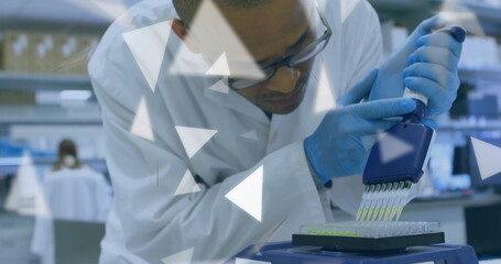 Dispensing technician wearing safety glasses, lab coat using pipette into microplate at lab bench