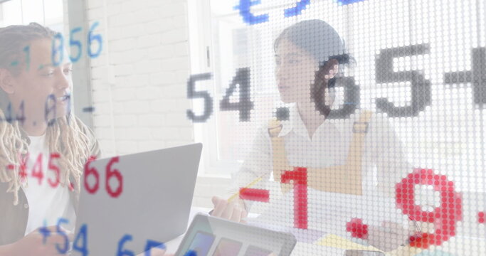 Reviewing man in blazer, woman in overalls checking financial overlay in office, with laptop pencil